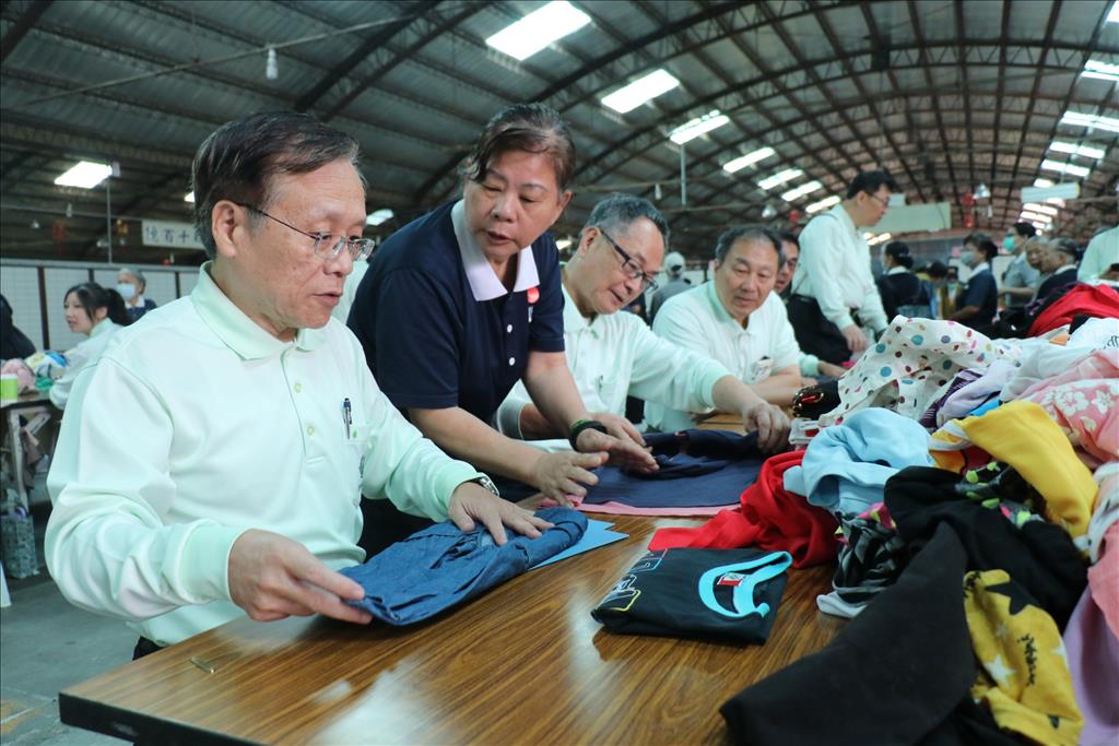 慈濟志工指導簡守信院長（左一）等同仁整理二手衣做法。
