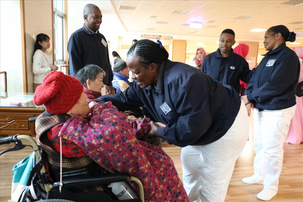 南非本土志工與候診病人互動。