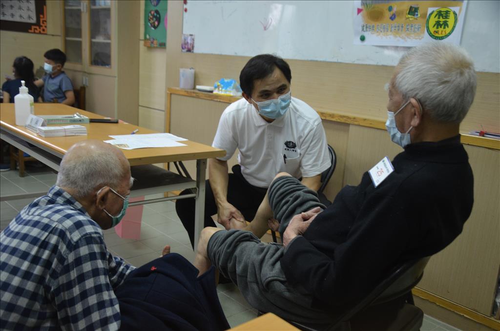 簡瑞騰醫師為雙腳水腫91歲的黃先生觸診後，判斷是內科，轉請林榮生醫師看診。（圖為慈濟基金會提供）